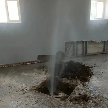 Water gushing from a hole during a leak detection