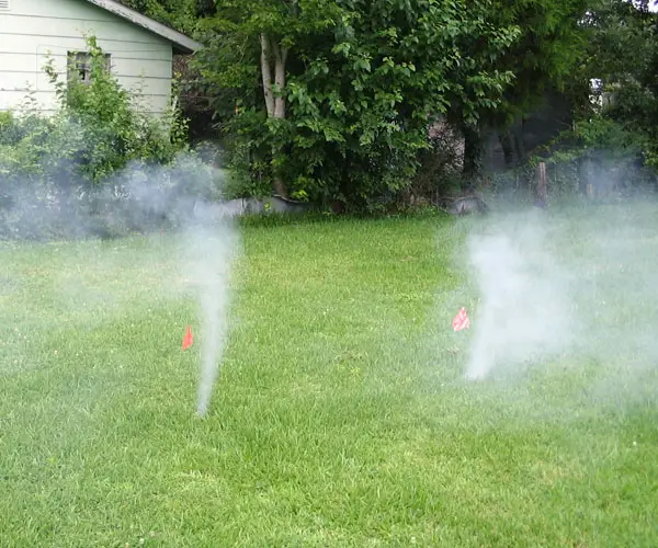 sewer leaking smoke in a yard during a sewer smoke test